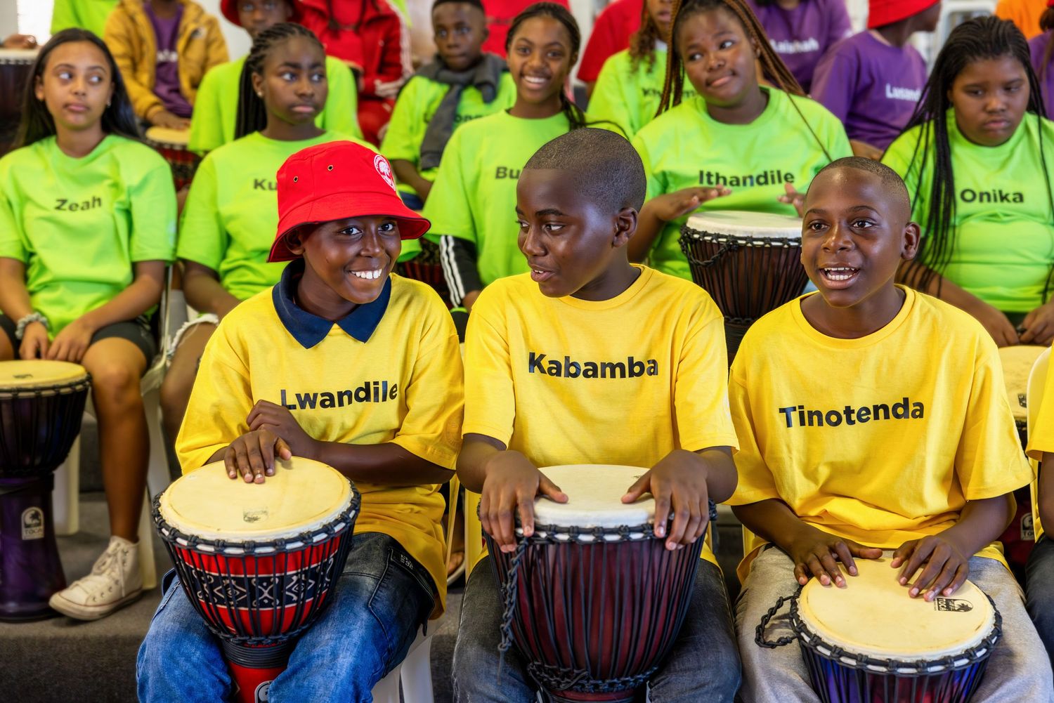 Participants in bright yellow and neon shirts seated together at an event.