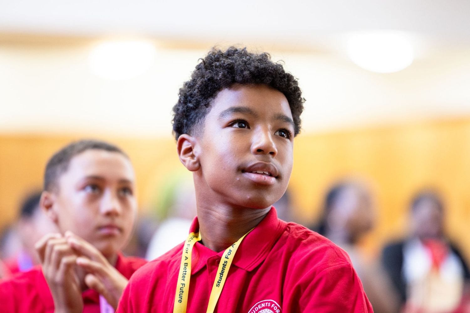 Students in red uniforms attending an educational program.