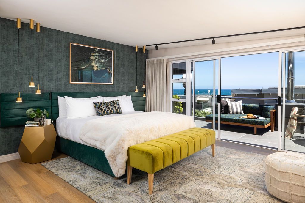 Modern luxury apartment interior with dark green walls and panoramic ocean views showcases contemporary furnishings.