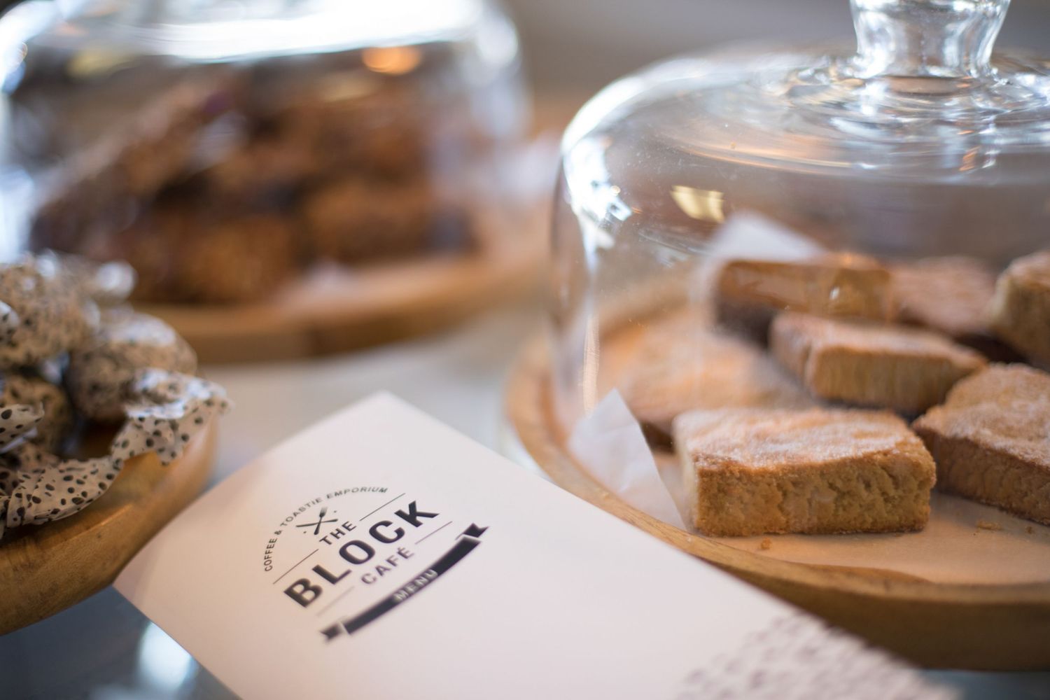 Close-up of cafe table settings with coffee cups and wooden serving boards.