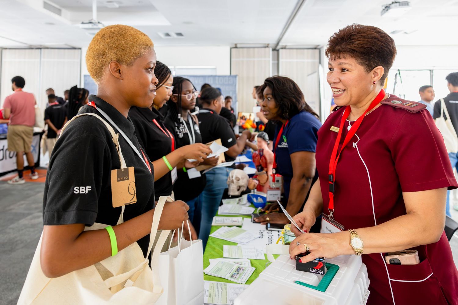 Career fair attendees interacting at registration tables during a professional development event.