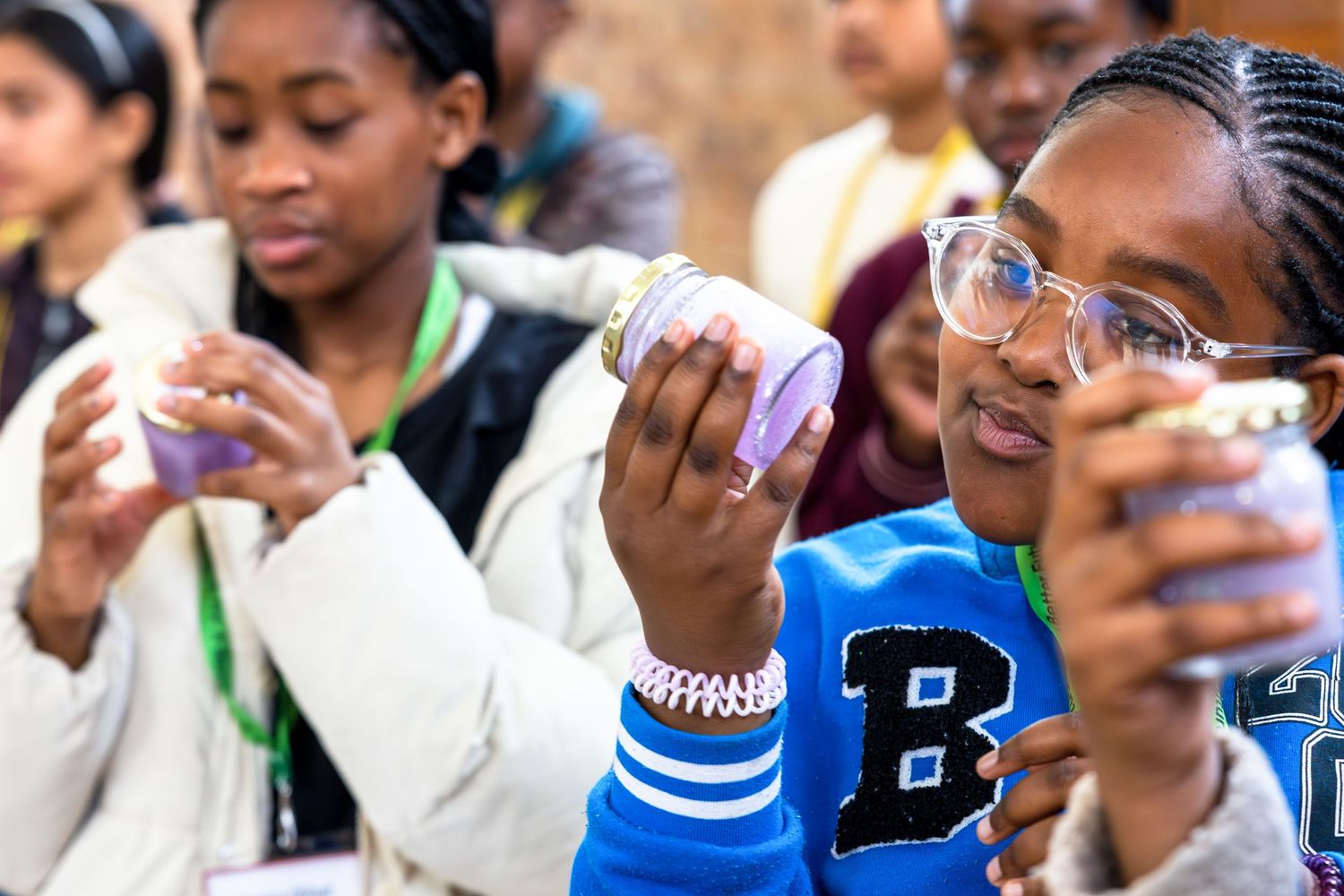 Students holding and examining purple objects during interactive learning session.
