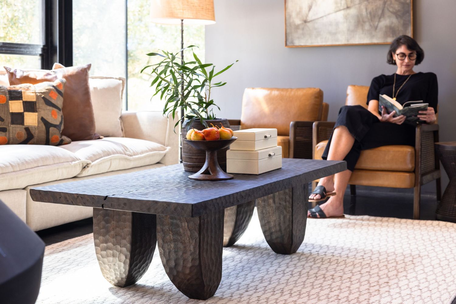 Modern living room with cozy seating, geometric pattern rug, and indoor plants creating a stylish home environment.