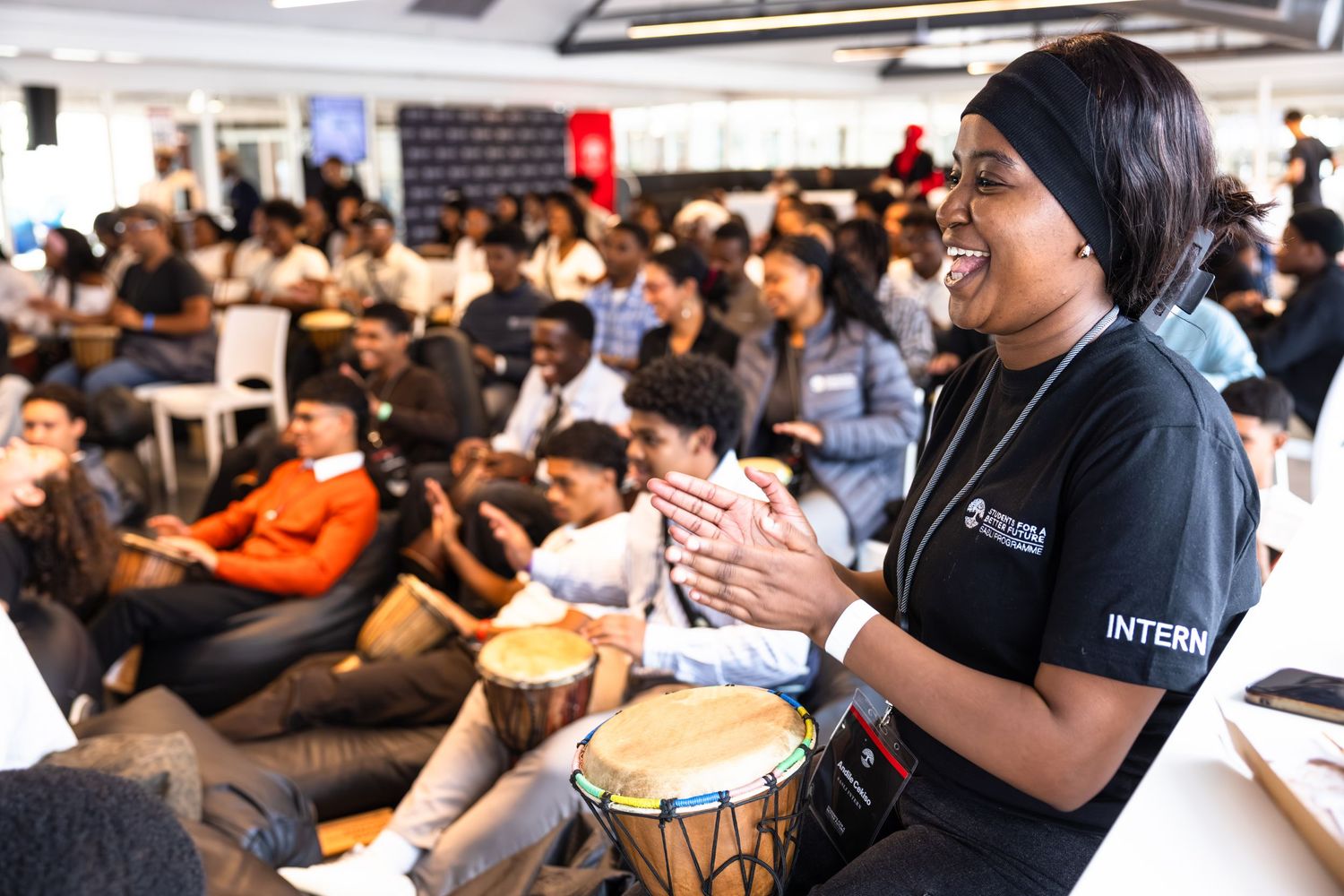 Participant plays djembe drum during an interactive workshop session.