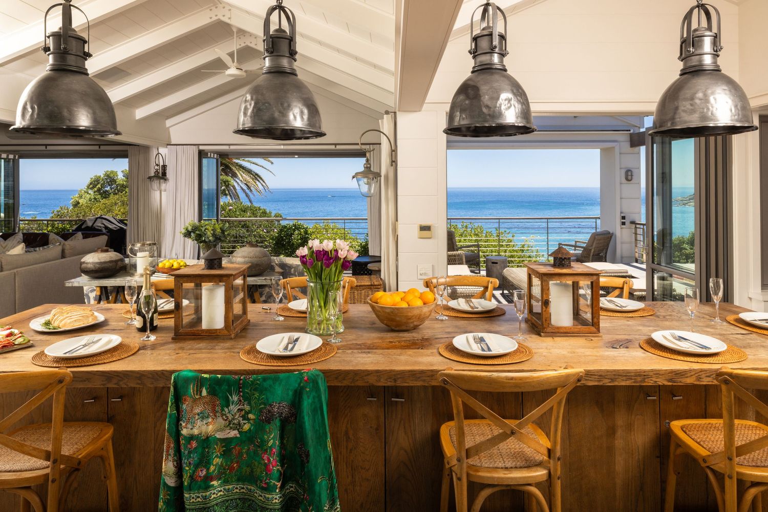 Elegant dining space with pendant lighting and expansive windows showcasing stunning ocean vistas.
