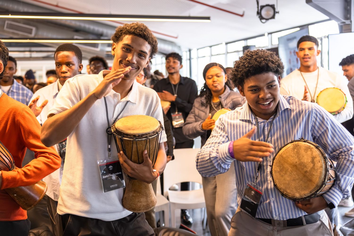 Participants engage in a lively drum circle activity during a corporate team building event.