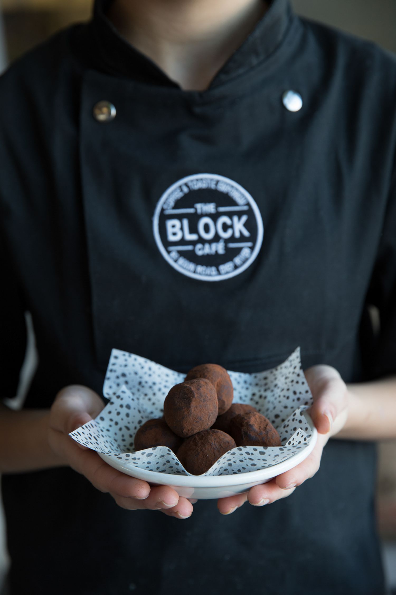 Chocolate truffles served on a decorative paper-lined plate with Block Cafe branding visible.