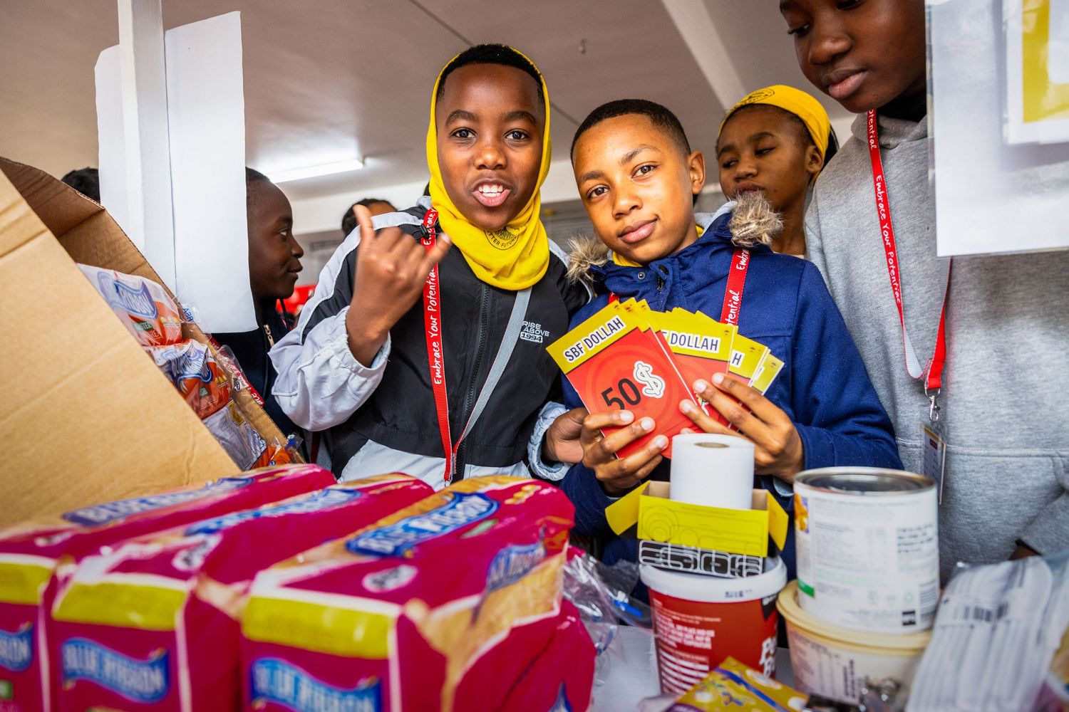 Youth selecting snacks and food items from boxes at a community event.