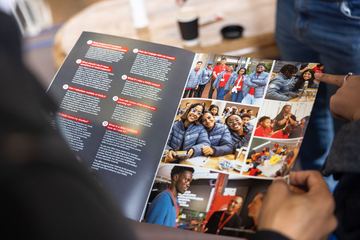 Person flips through pages of a glossy magazine or photo album showing various group photos and text layouts.