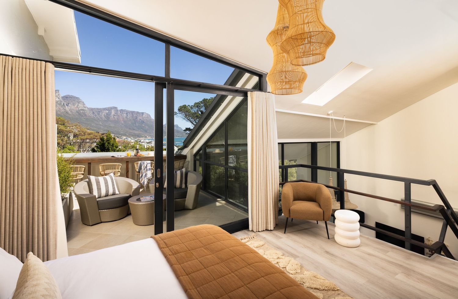 Modern luxury villa interior with panoramic mountain views features an open floor plan and contemporary furnishings.