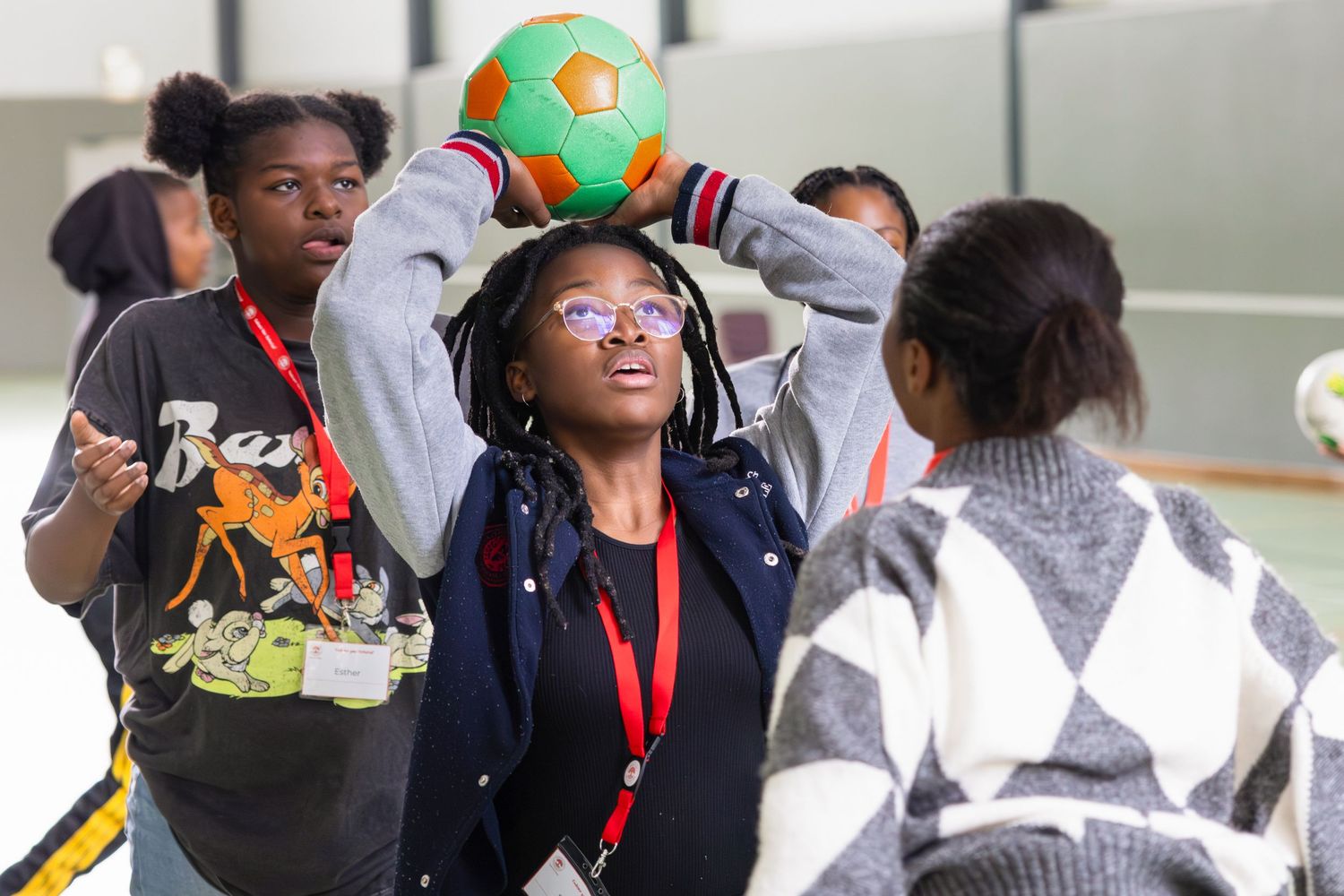 Students engage in active sports game with colorful ball in recreational setting.