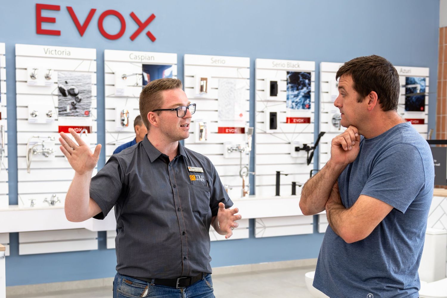 People talking near EVOX signage in a modern retail environment.
