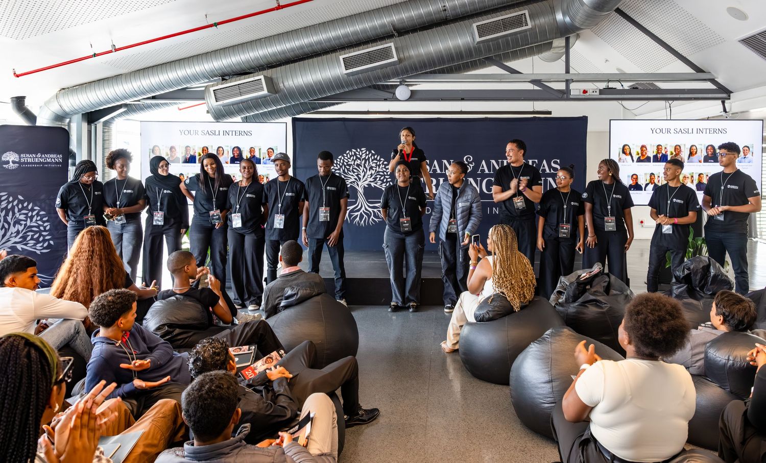 Large group of people seated in rows during a corporate presentation or workshop.