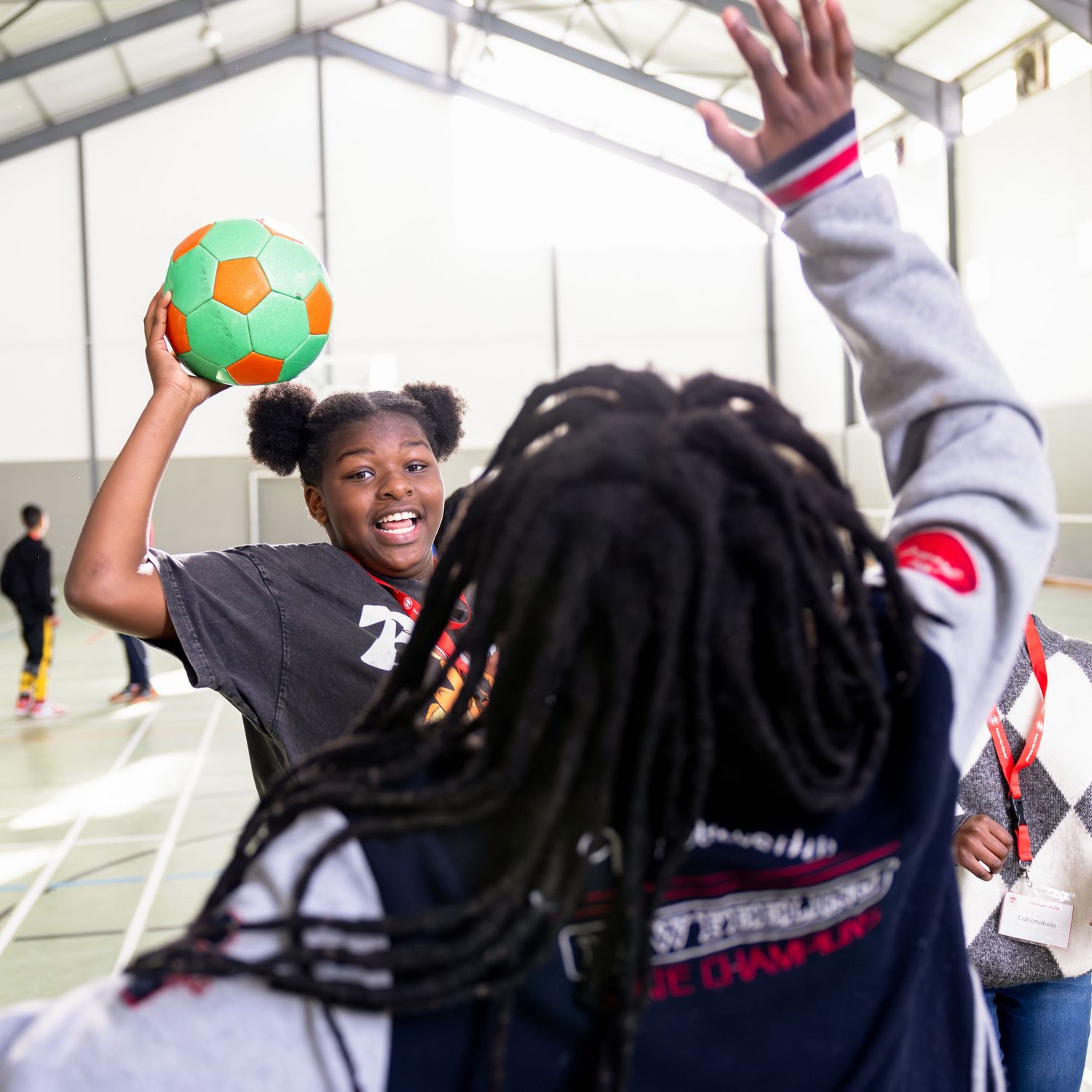 Basketball players reach for a rebound during an intense indoor game competition.