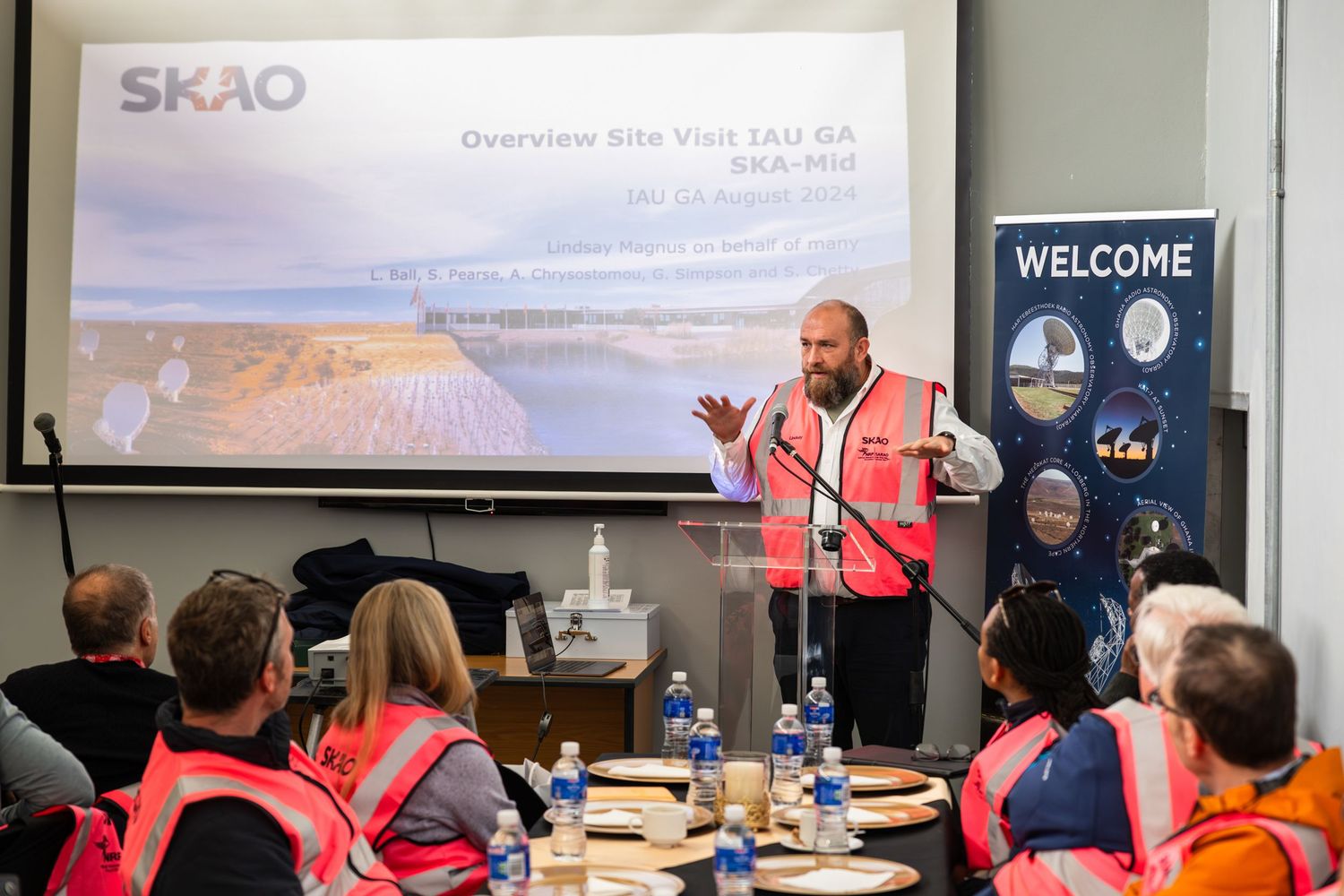 Presentation being given to workers in high-visibility vests at a meeting.
