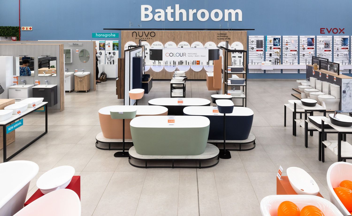 Retail bathroom section with modern fixtures and displays under bright lighting.