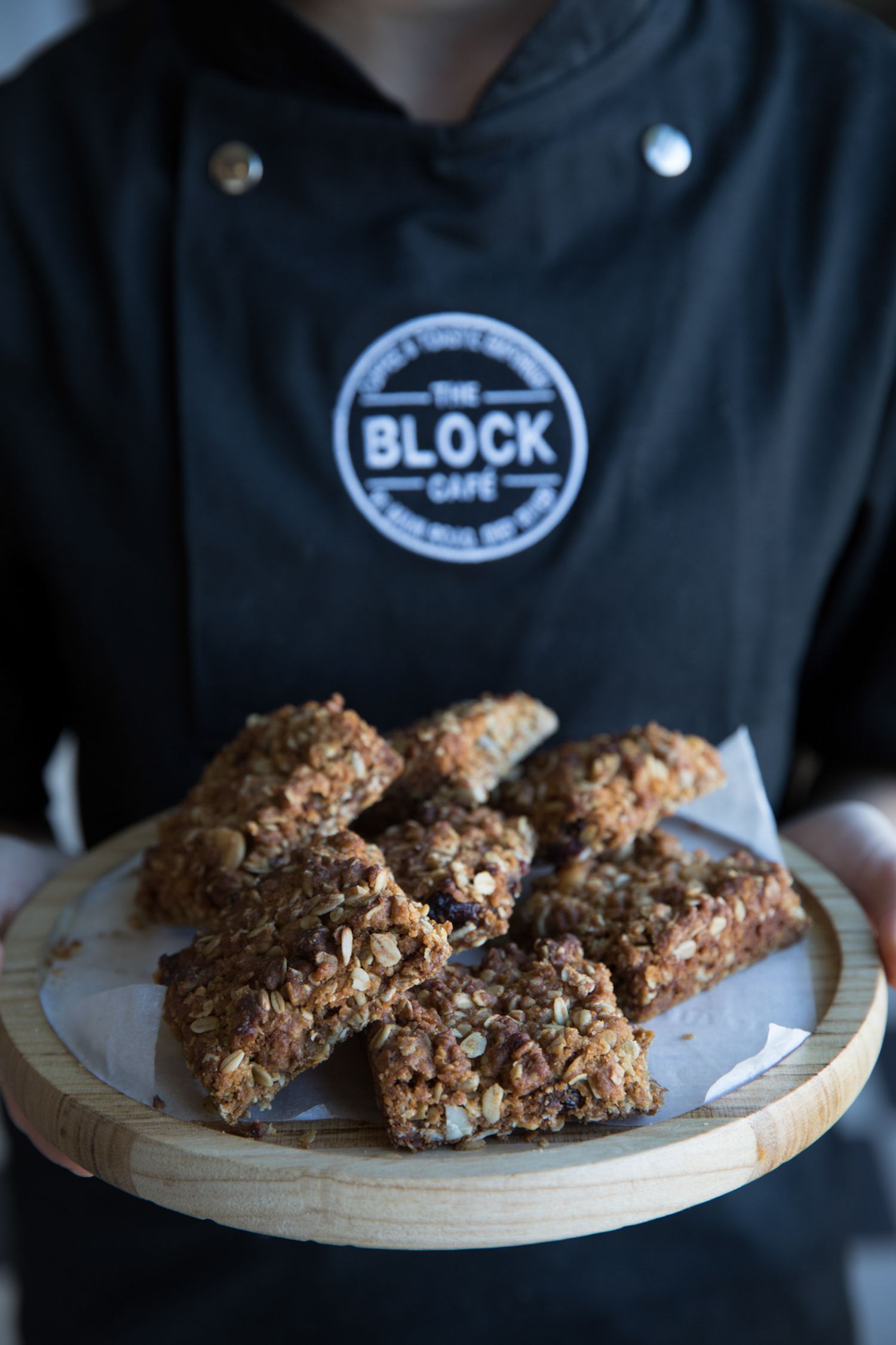Homemade granola bars arranged on a wooden serving board at Block Cafe.
