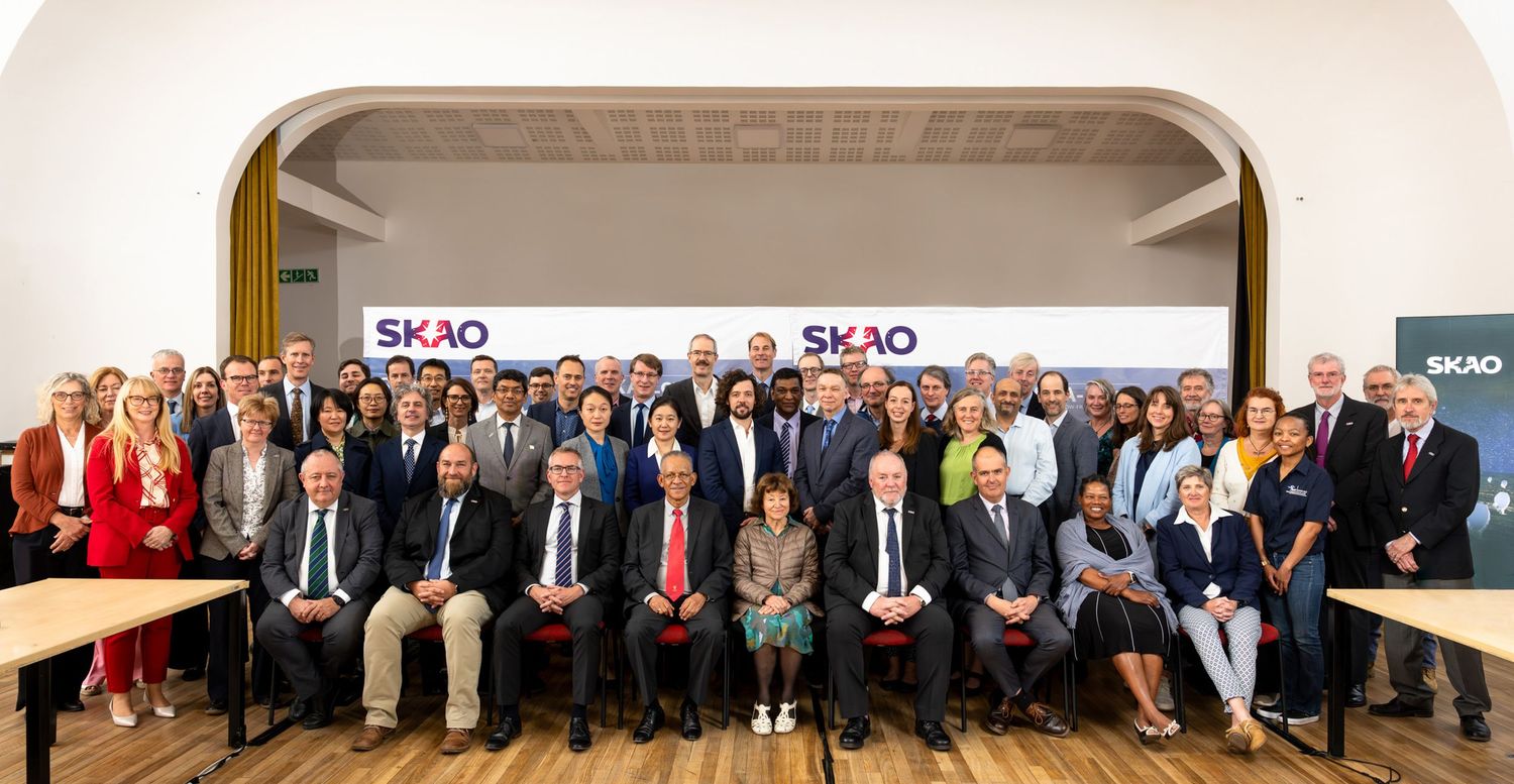 Large formal group photo of conference attendees in professional attire.