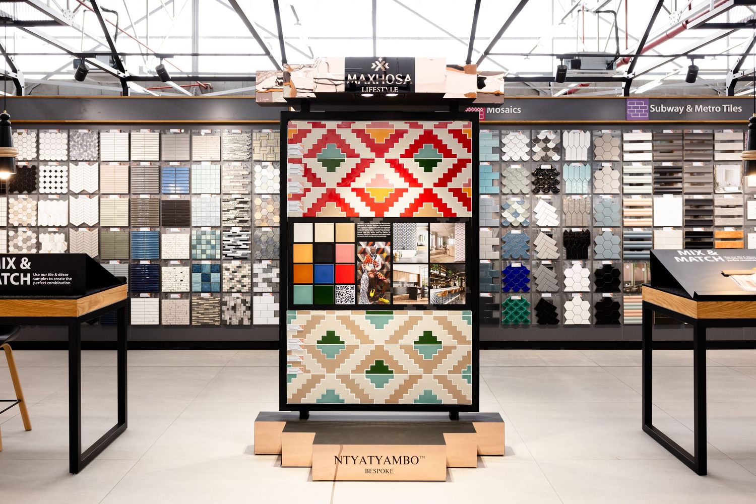 A modern retail store interior with sleek black display cases and geometric wall patterns in neutral tones.