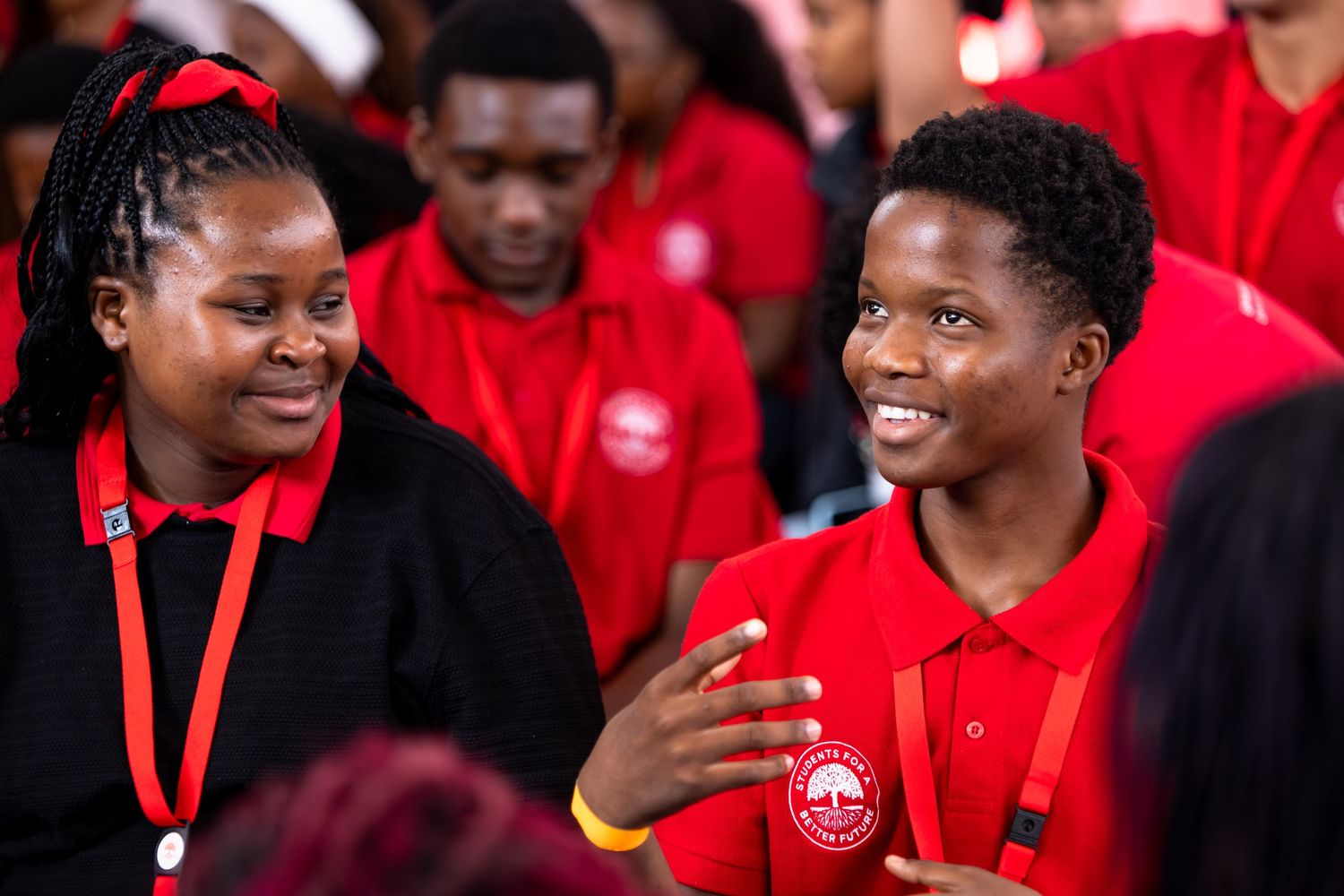 A group wearing red shirts gather together at an indoor event.