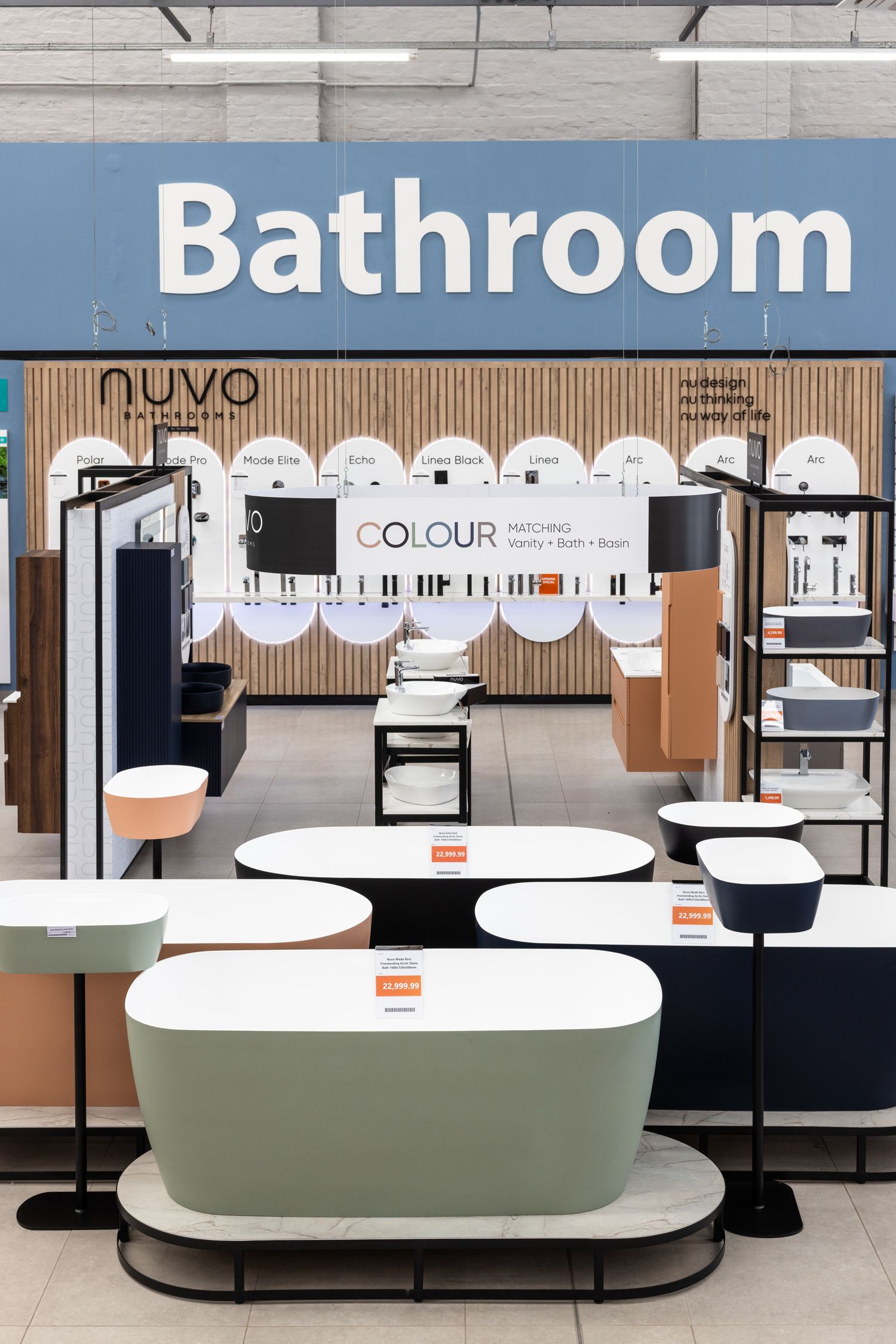 Contemporary bathroom display area showcasing freestanding tubs and fixtures in neutral tones.