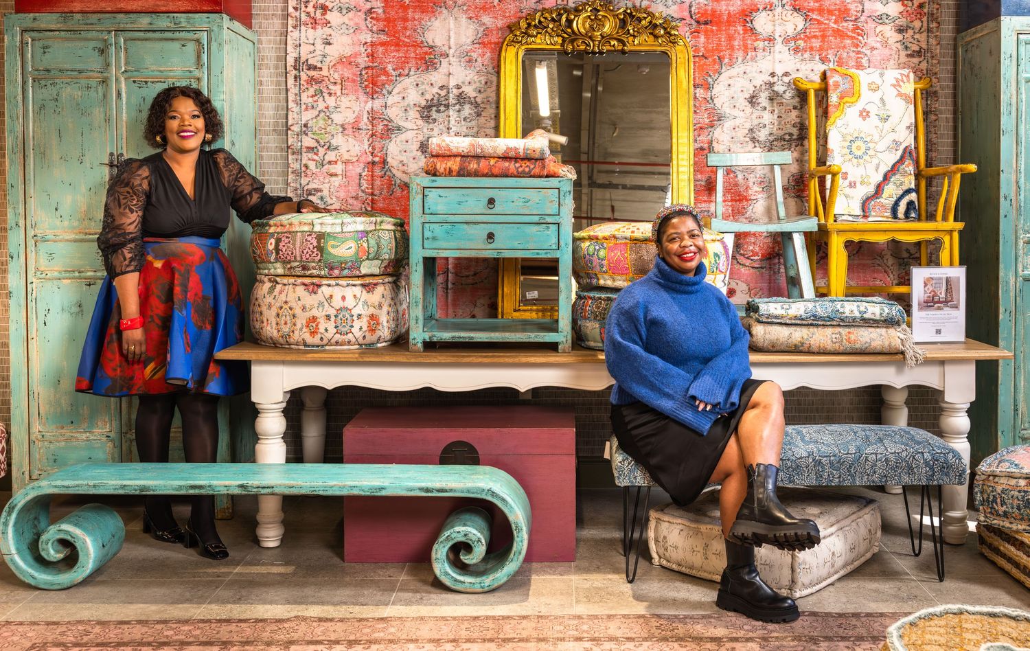 A row of colorful vintage storefronts with decorative architectural details and people sitting outside.