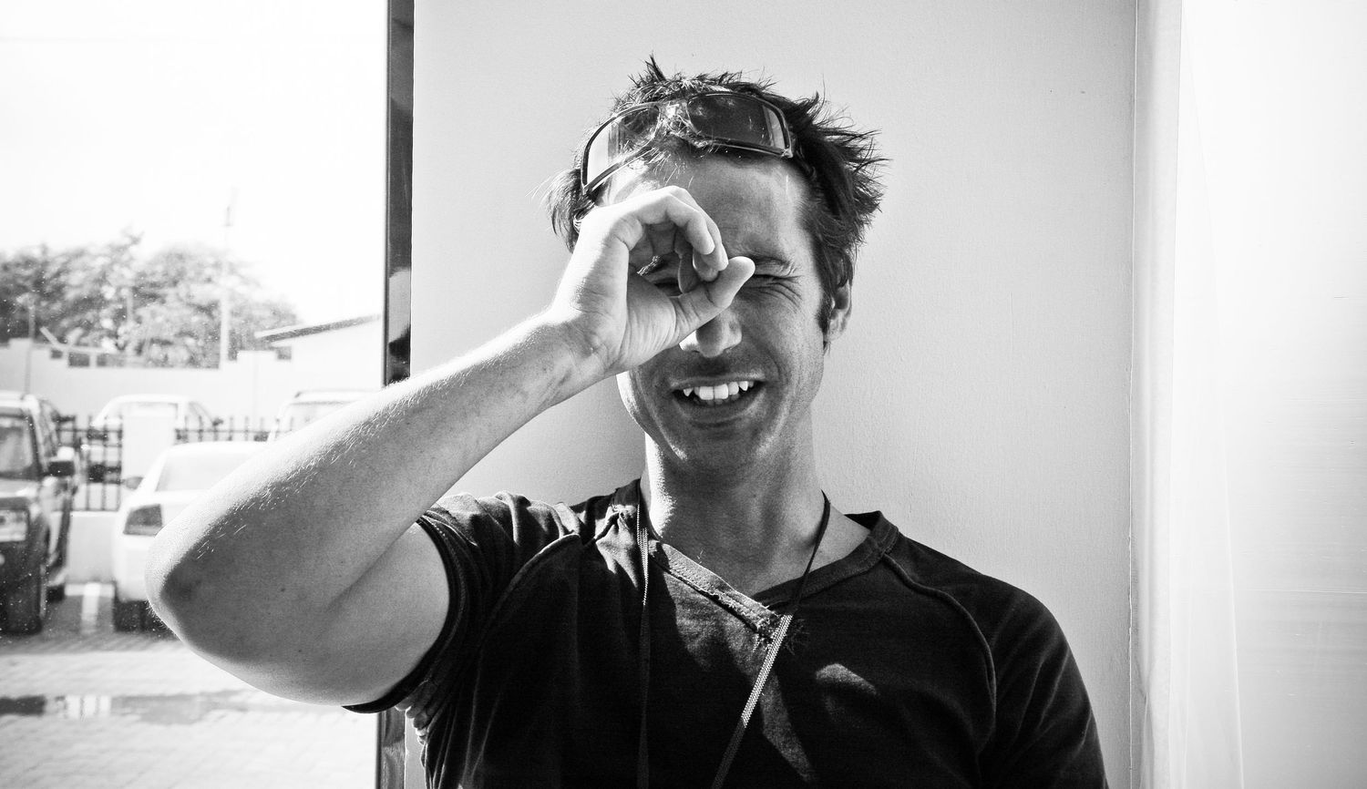 A black and white collage of candid portrait photos showing joyful expressions and laughter.