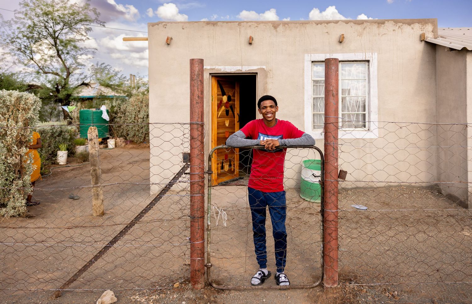 Simple house facades with small windows and doorways in a dry rural community landscape.