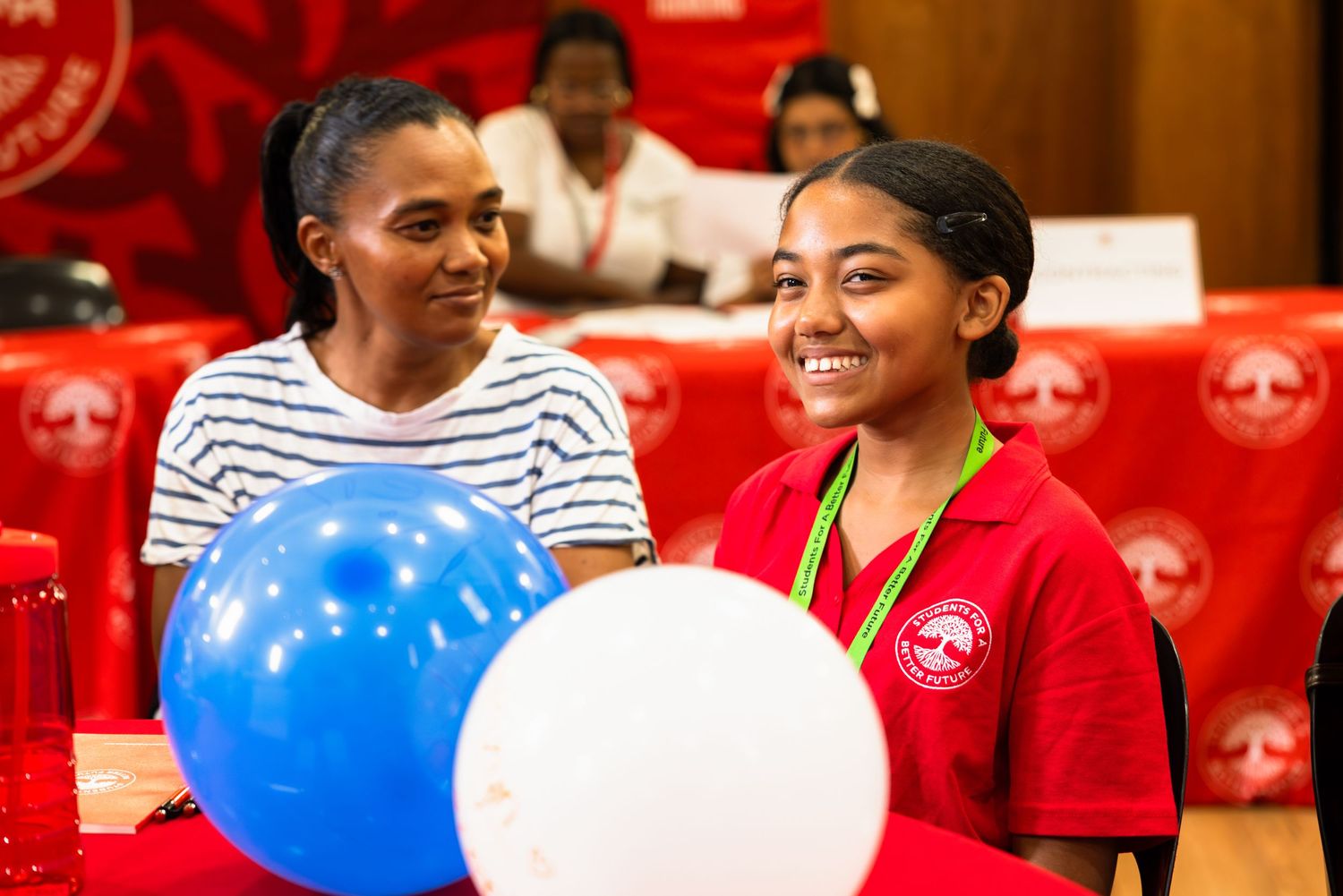 Two participants with colorful balloons at a community program.