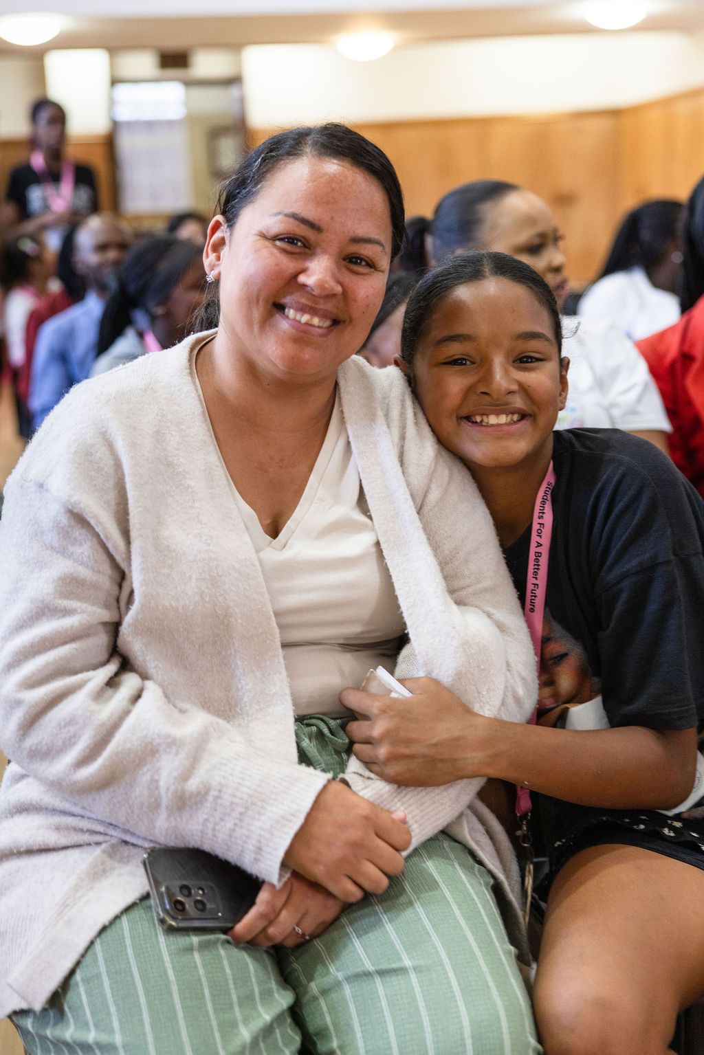 Two people share a warm embrace while sitting together, displaying genuine joy and connection.