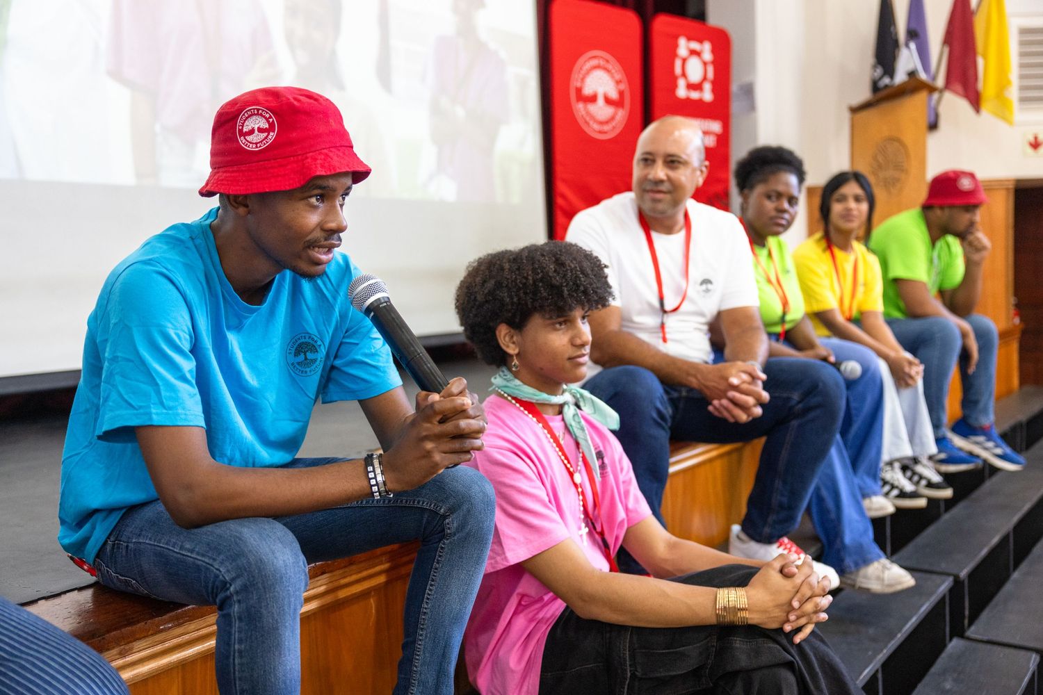 Students in casual attire attending a presentation in an auditorium.