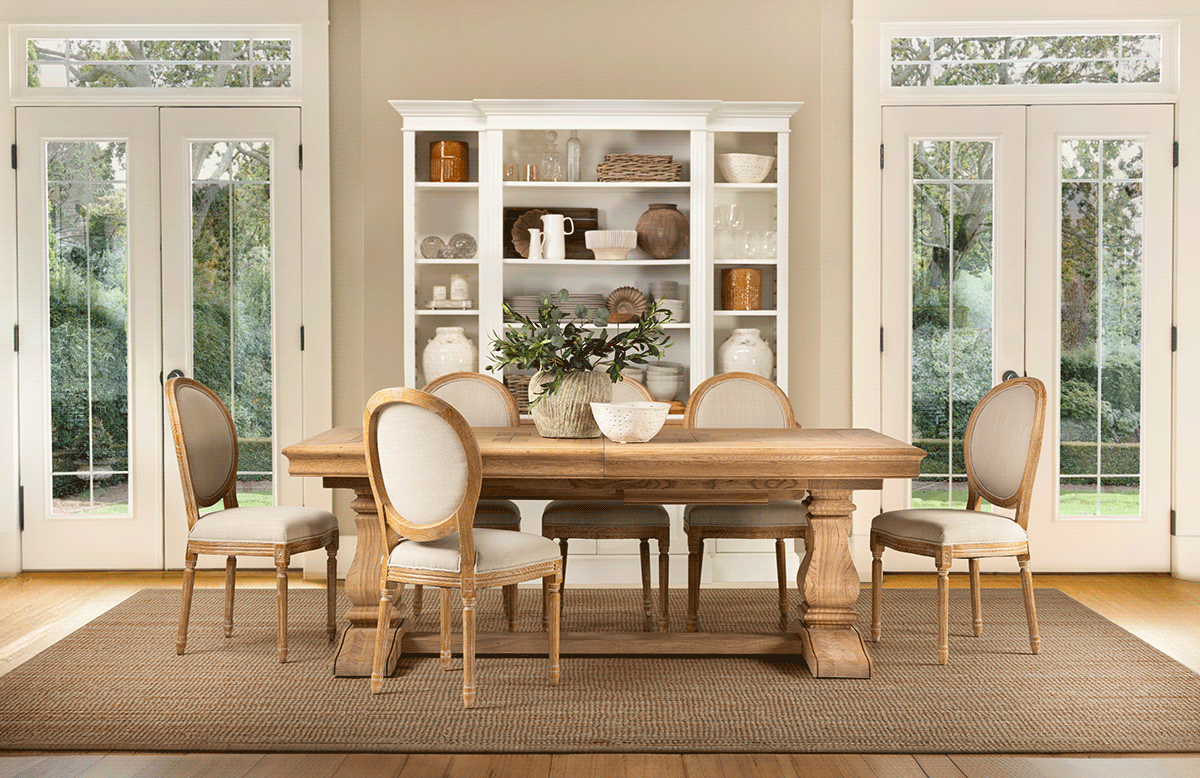 Bright transitional living space with built-in white shelving and natural light from large windows.