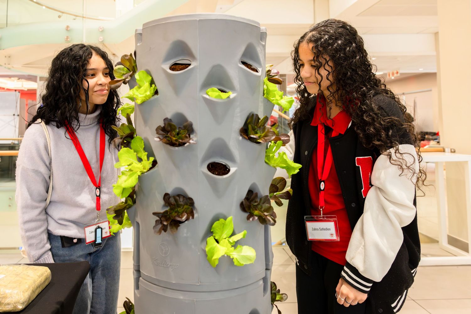 Participants work together on a wall-mounted science activity in a brightly lit educational space.