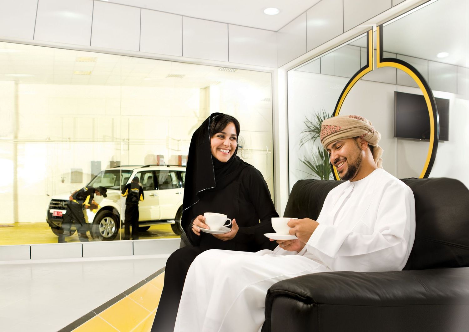 Modern automotive service center interior with bright lighting and staff at work stations.