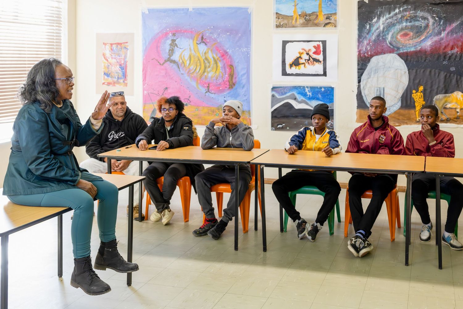 Educational classroom session with colorful artwork displayed on walls.