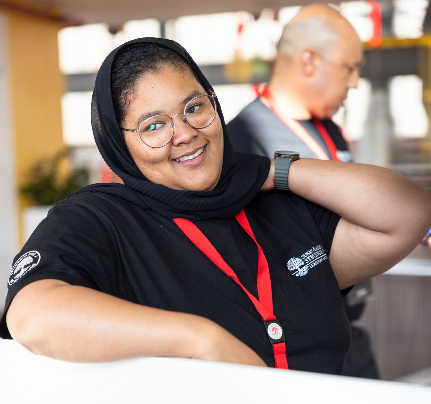 Attendees engage enthusiastically during a professional development event wearing black shirts with red lanyards.