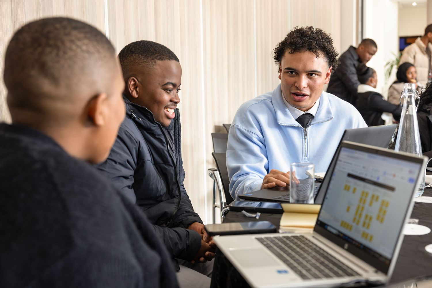 Colleagues reviewing data on a laptop screen during a professional business meeting.