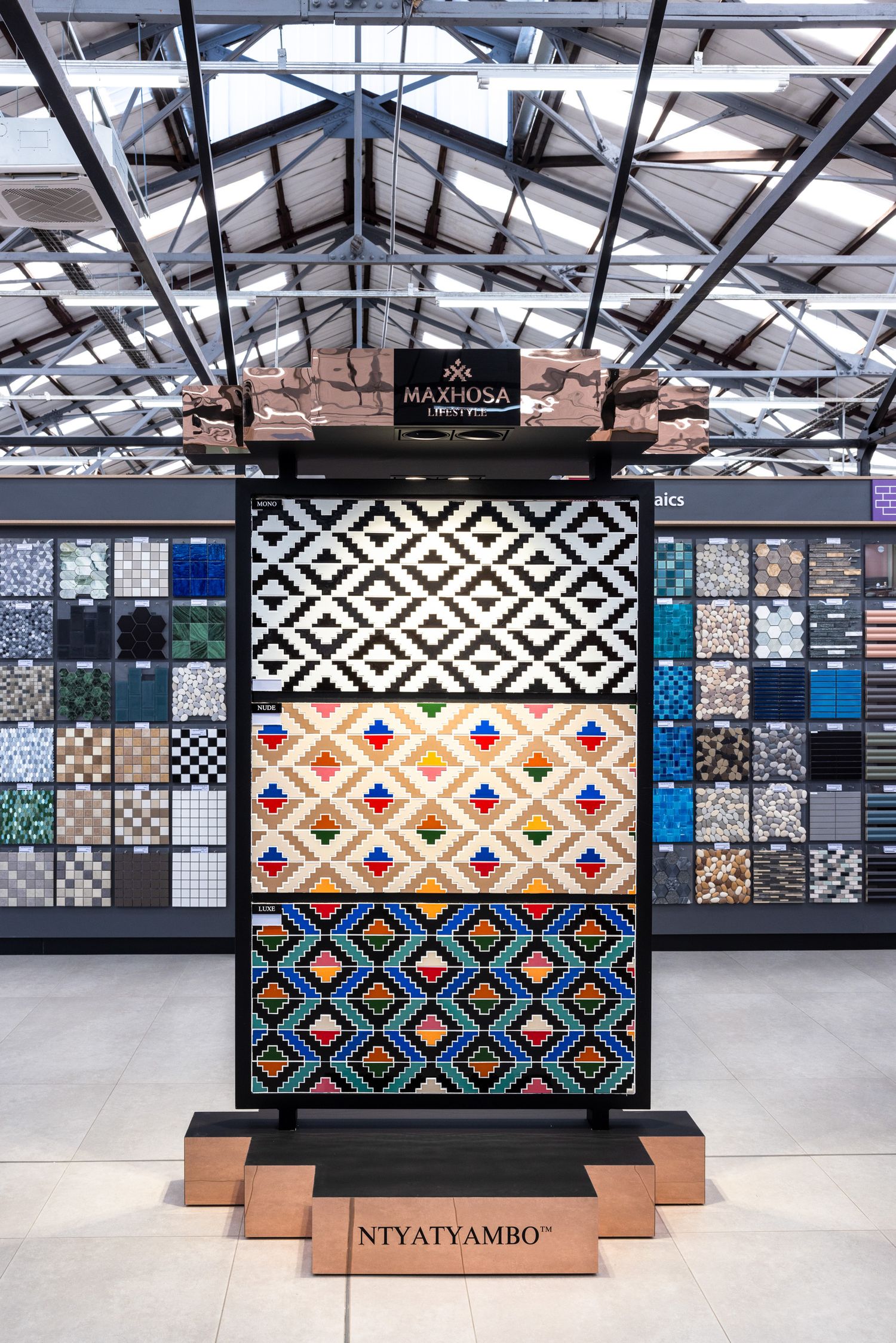 Colorful geometric tile display patterns showcased on black retail fixtures.