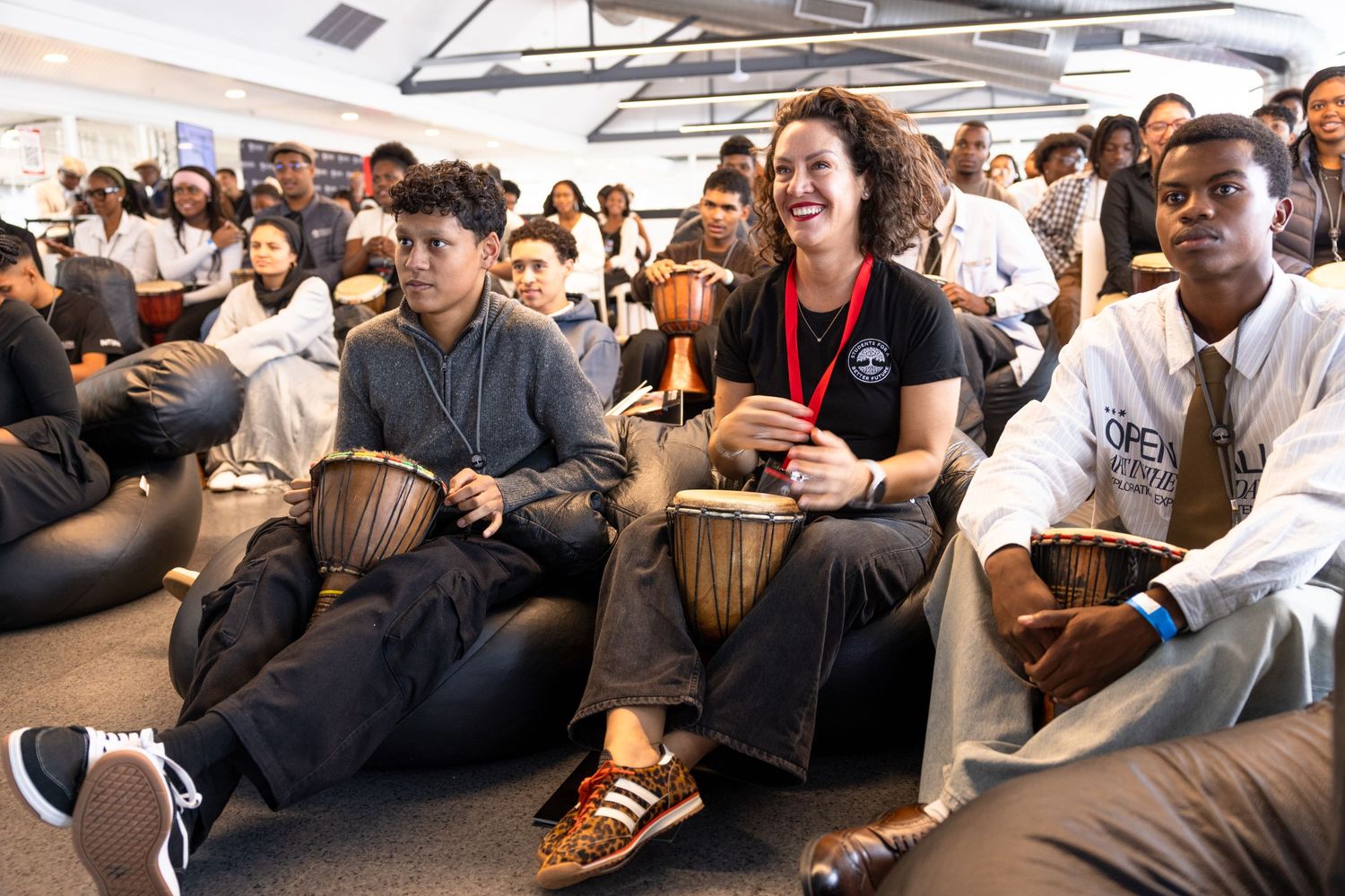Diverse audience members seated and engaged during presentation at indoor corporate event.