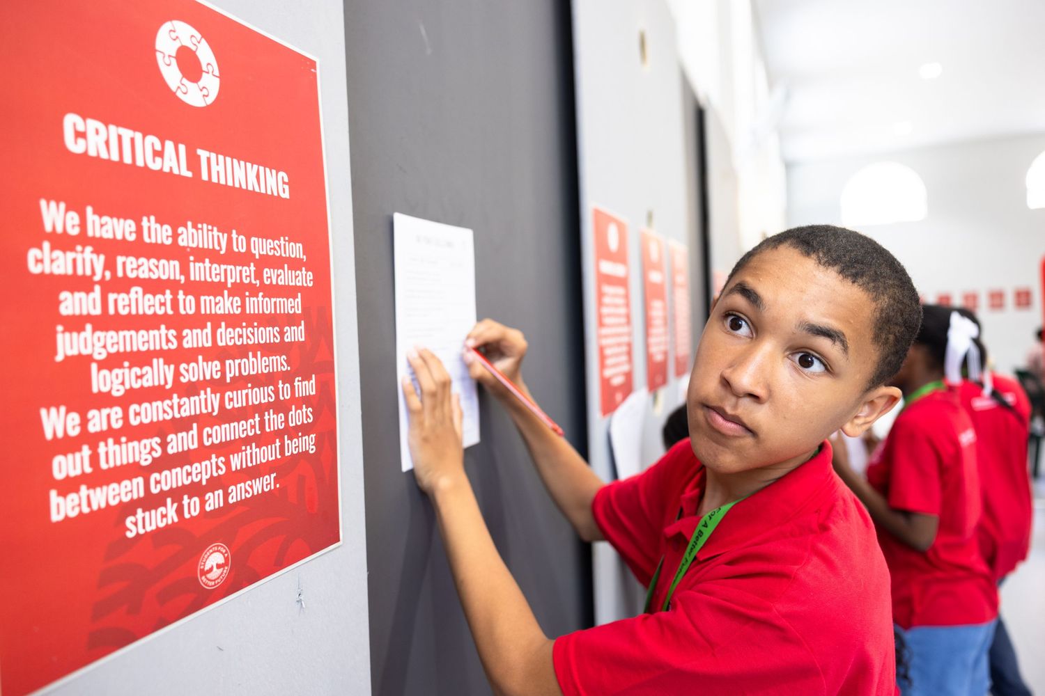 Red wall display showing educational messages and text about critical thinking.