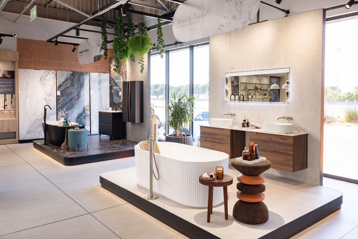 Luxurious open concept retail space featuring white floors, wooden accents and natural lighting.