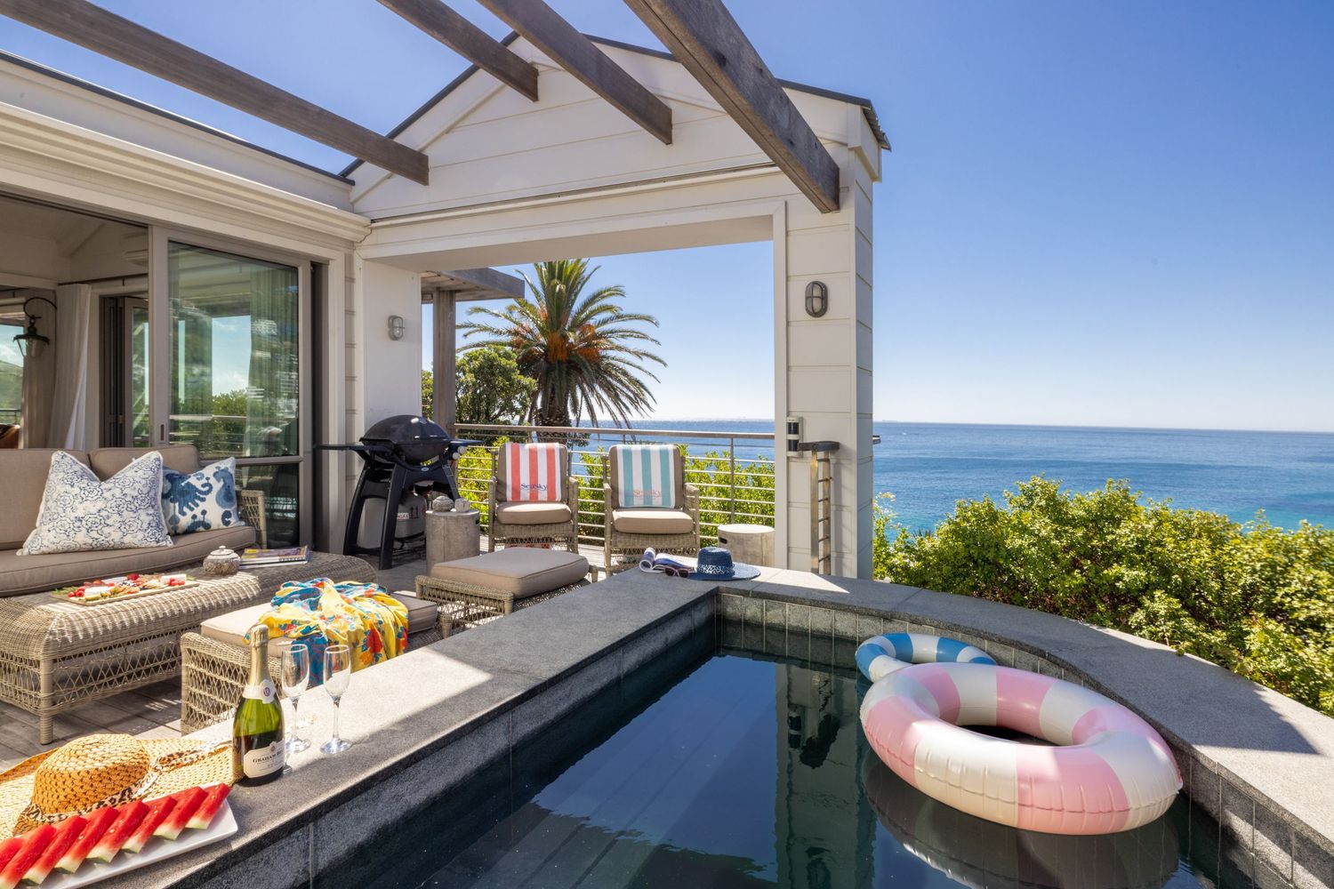 Panoramic coastal views from a luxury beachfront property with multiple balconies and outdoor living spaces.