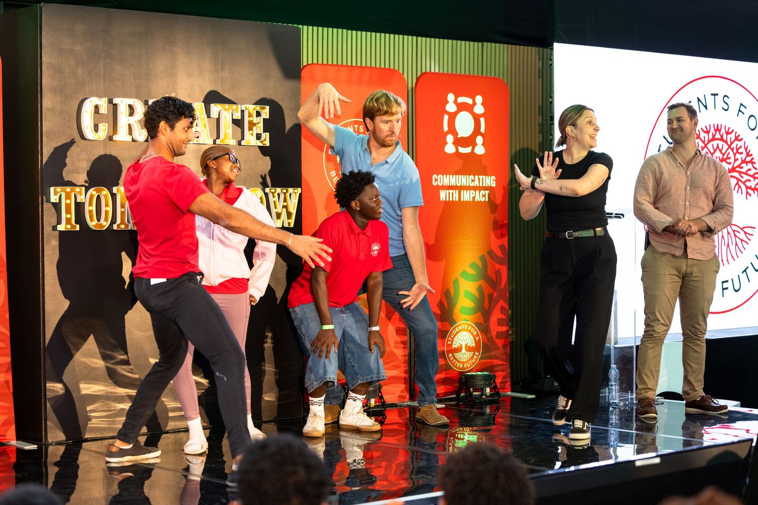 Conference participants lined up on stage during interactive presentation segment.