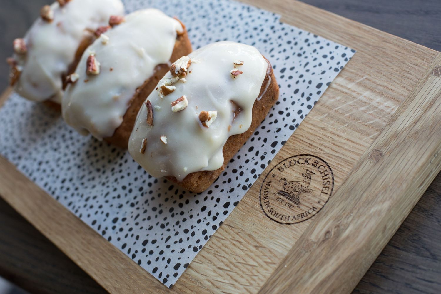 Gourmet pastries displayed on rustic wooden serving boards with delicate paper doilies.