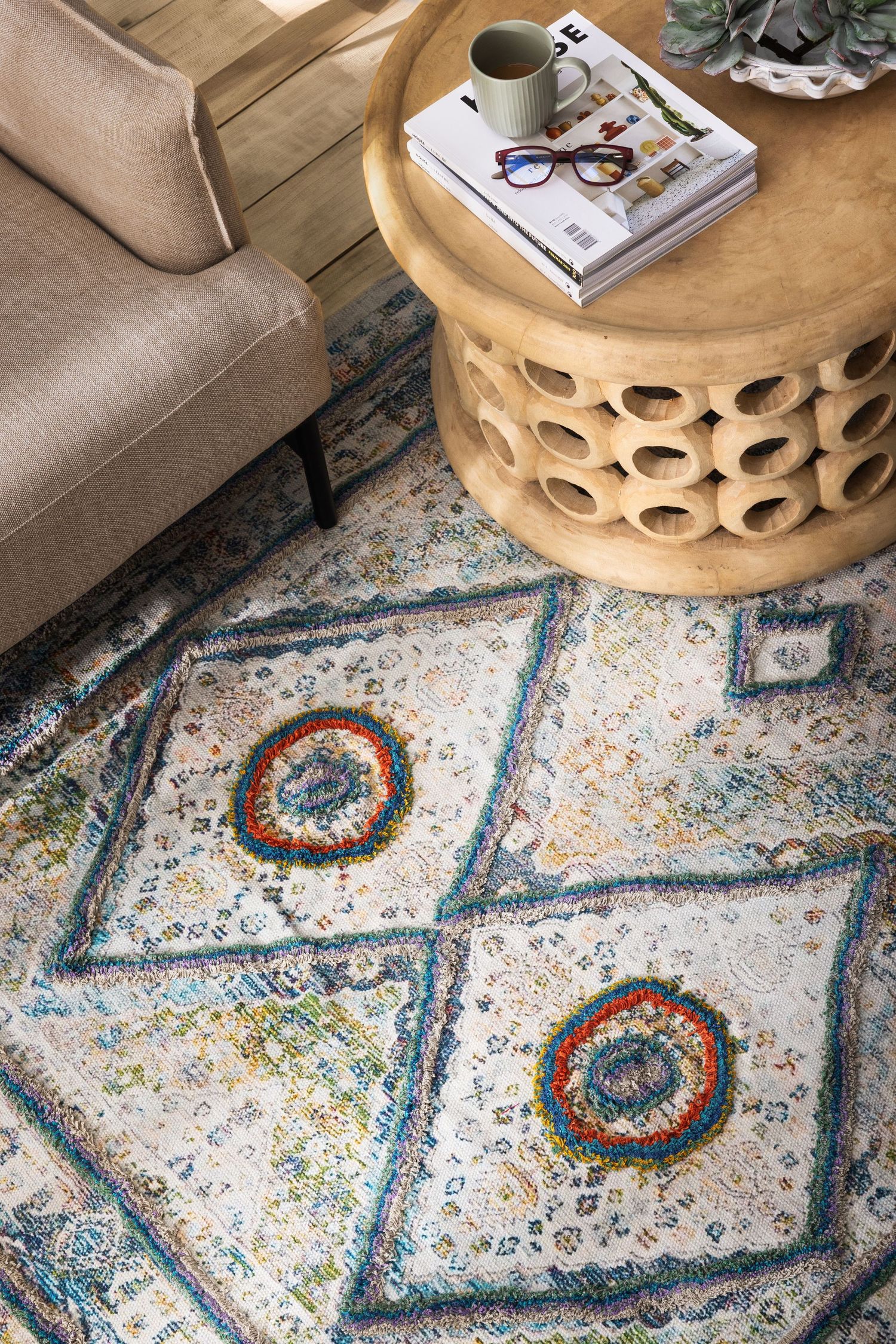 Close up shot of a vintage-style abstract patterned area rug with blue and orange circular motifs.