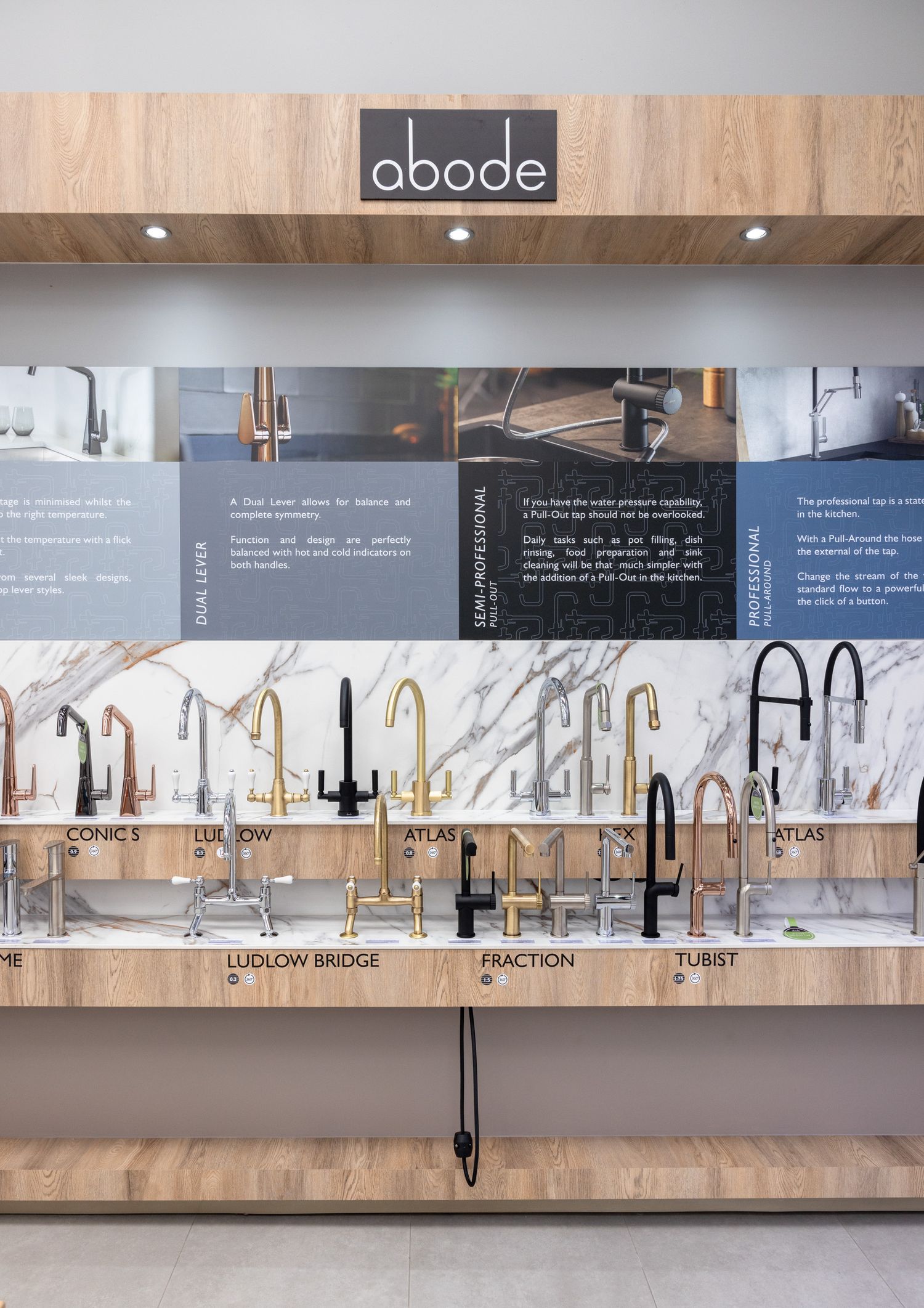 Kitchen faucet display wall featuring various styles and finishes with descriptive labels.