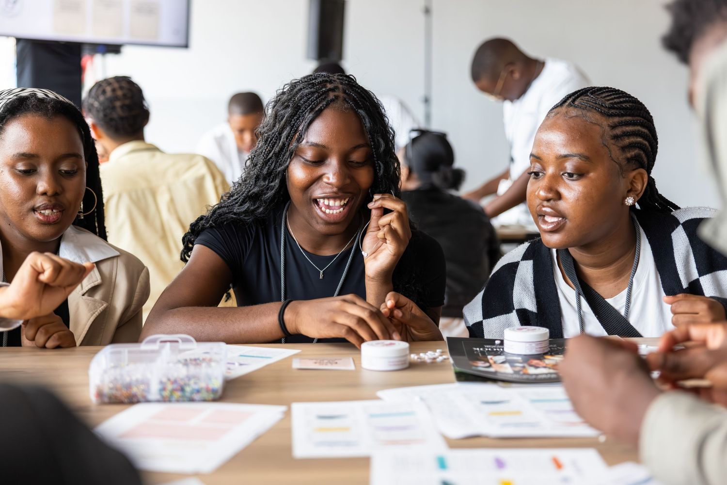 Students engage in animated discussion while collaborating at a classroom table with study materials.