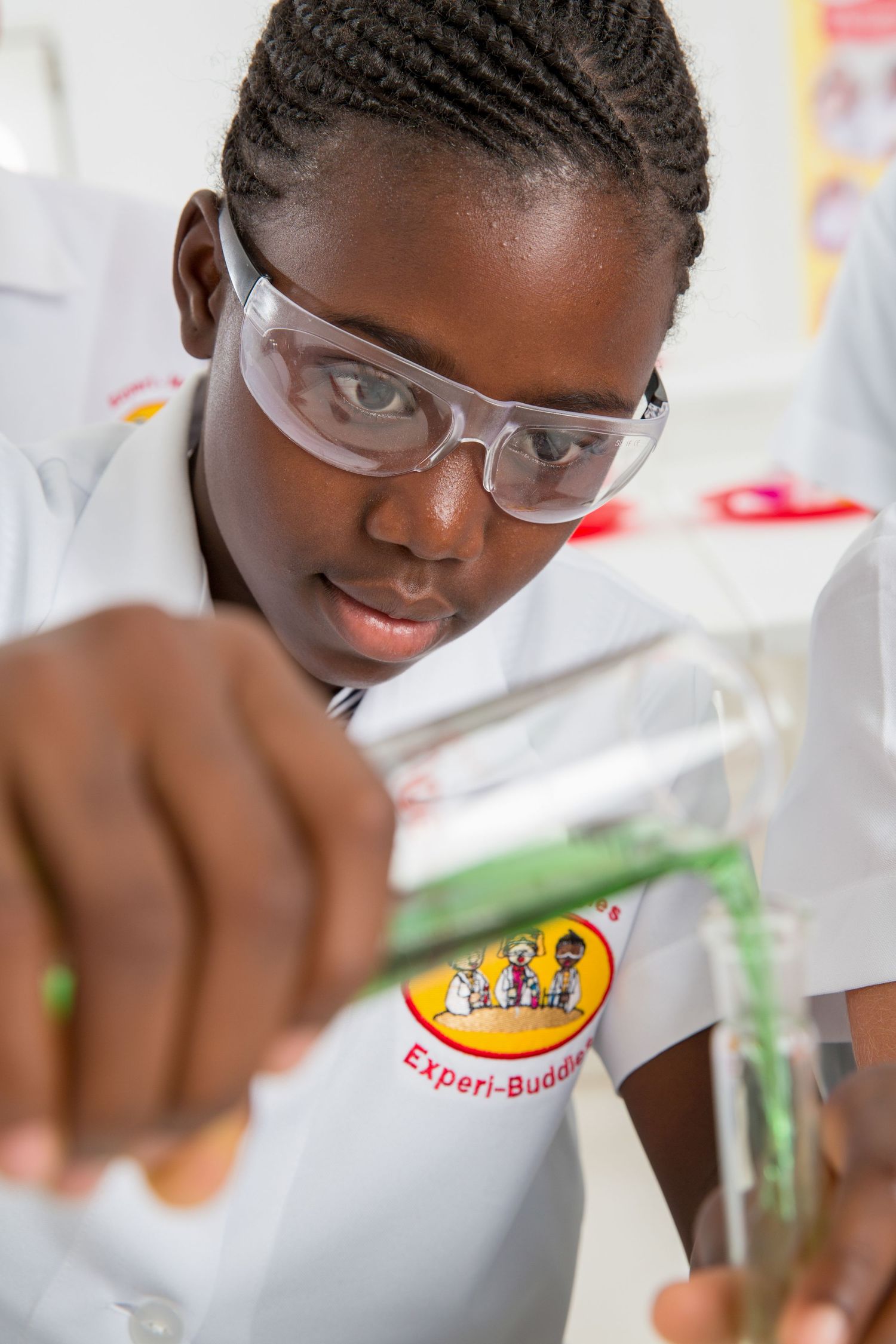 Close-up shots of laboratory experiments featuring vibrant colored solutions and safety equipment.