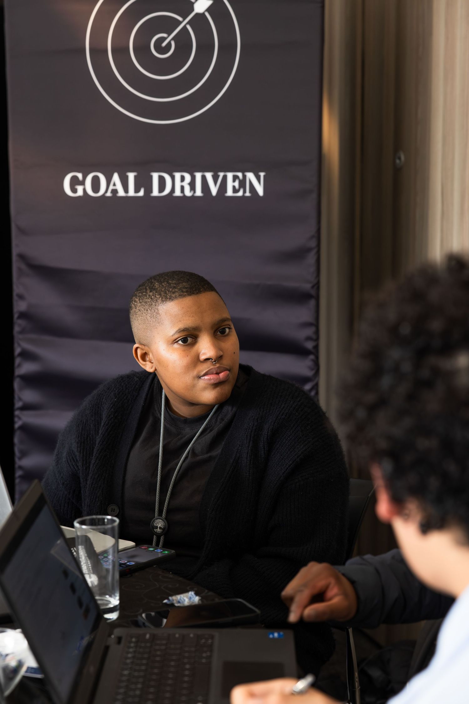 Student sitting beneath a 'Goal Driven' motivational banner during a work session.