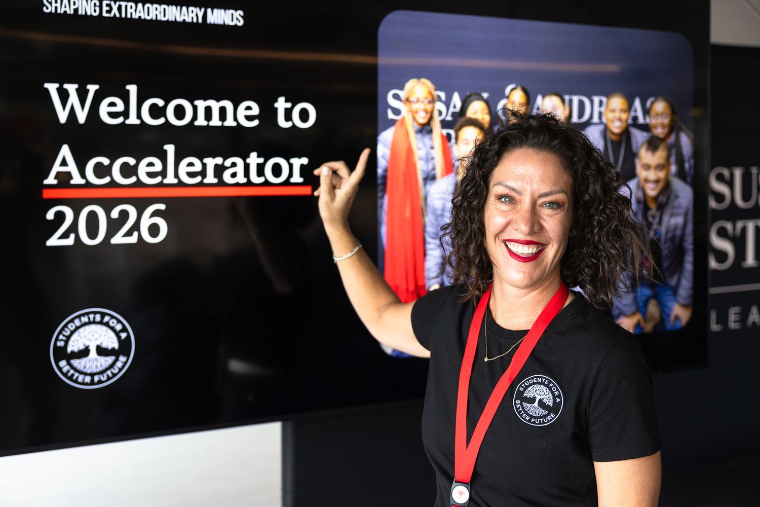 A group of people in black and red attire celebrate at what appears to be a startup or business event.